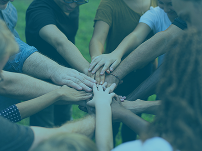 diverse group of people joining hands 