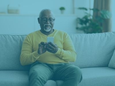 elderly man texting, man sitting on couch